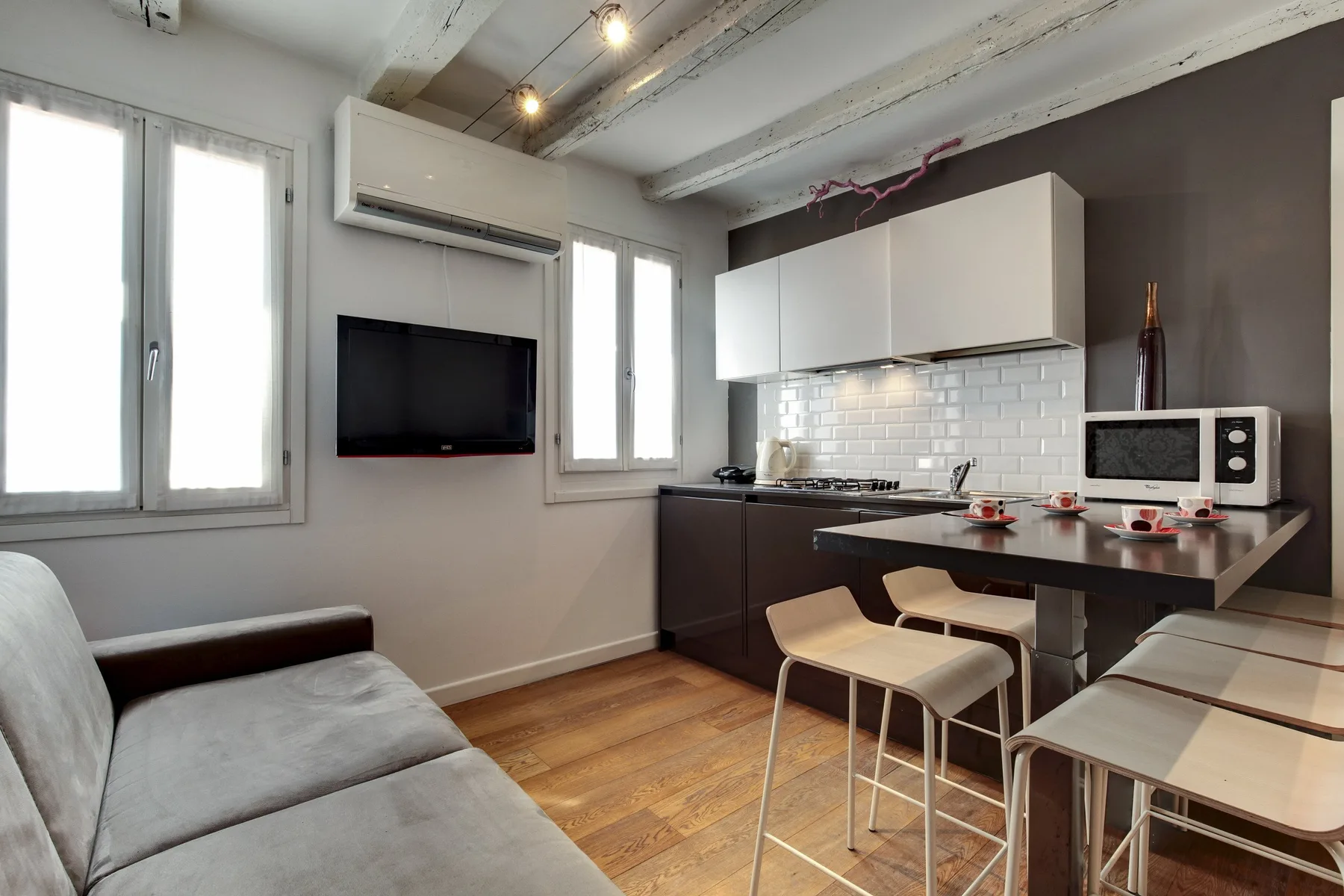Una luminosa sala de estar diáfana con barra de cocina y asientos.