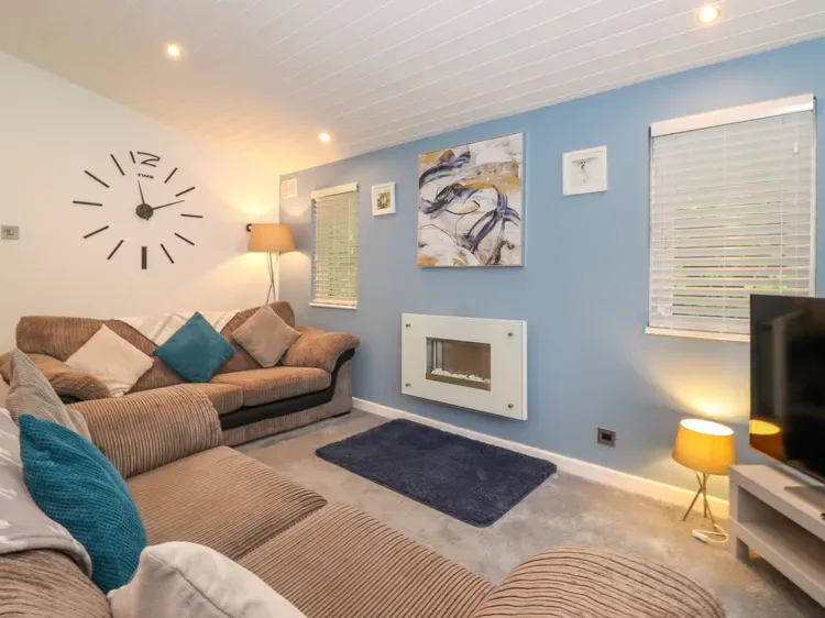 Living room with seating, a wall clock, and abstract artwork.