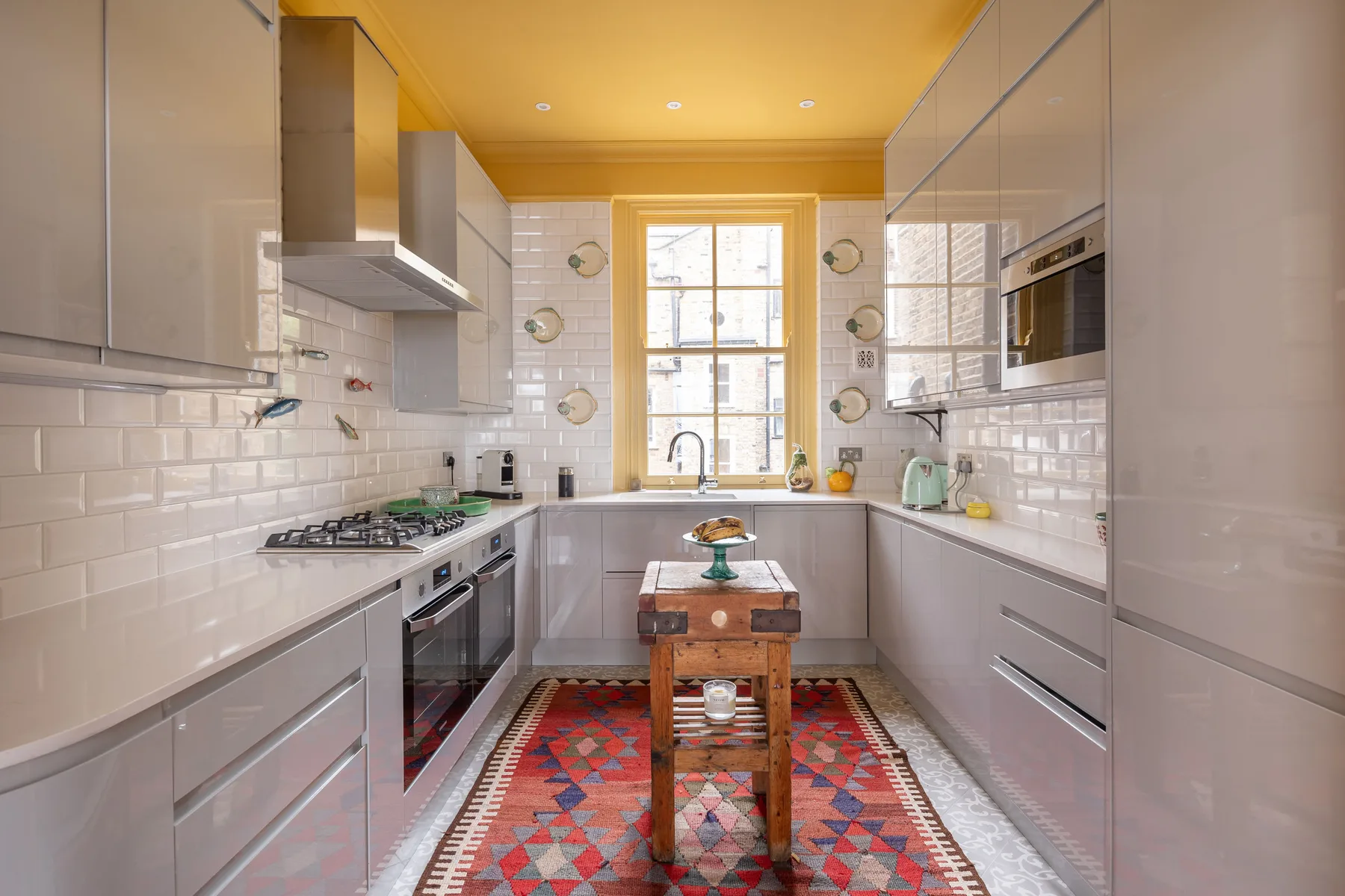 A bright galley kitchen with pale cabinets and a central island.
