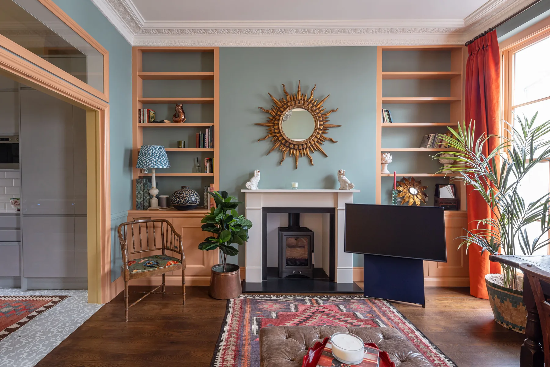 A living room with a fireplace, built-in shelves, and a patterned rug.