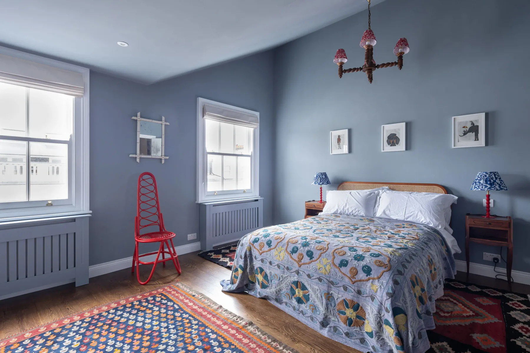 A bedroom with a bed, patterned bedding, and blue walls.