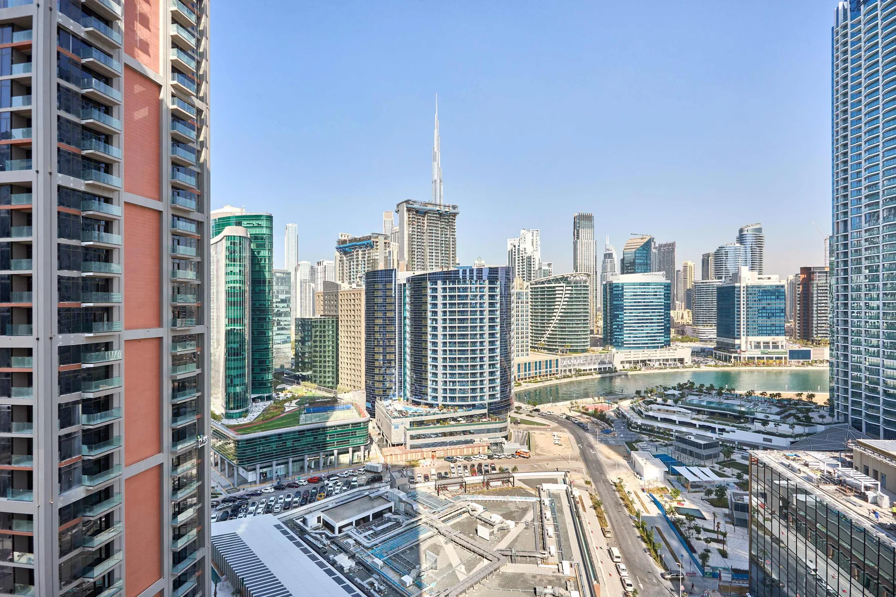 A city skyline of high-rise buildings surrounds a large construction site.