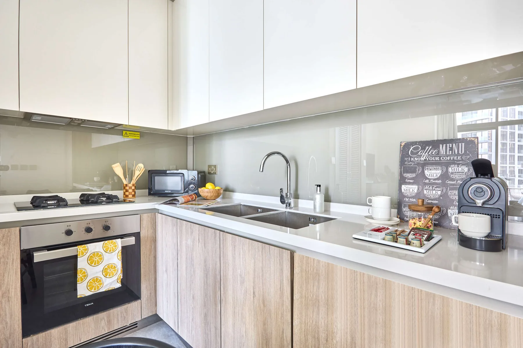 A bright kitchen with a countertop, sink, and cooking appliances.