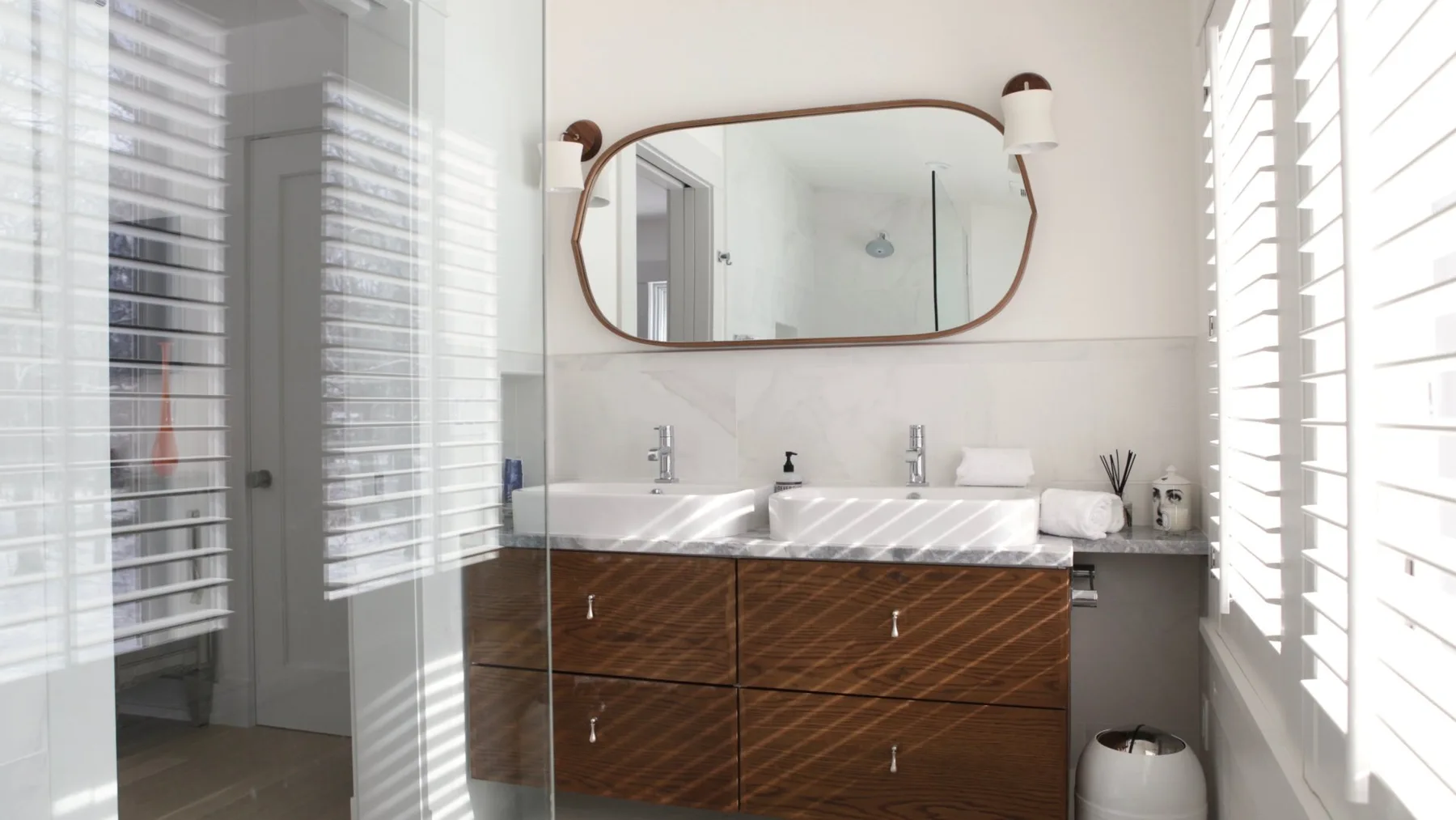 A bright bathroom with a double sink vanity and a large wall mirror.