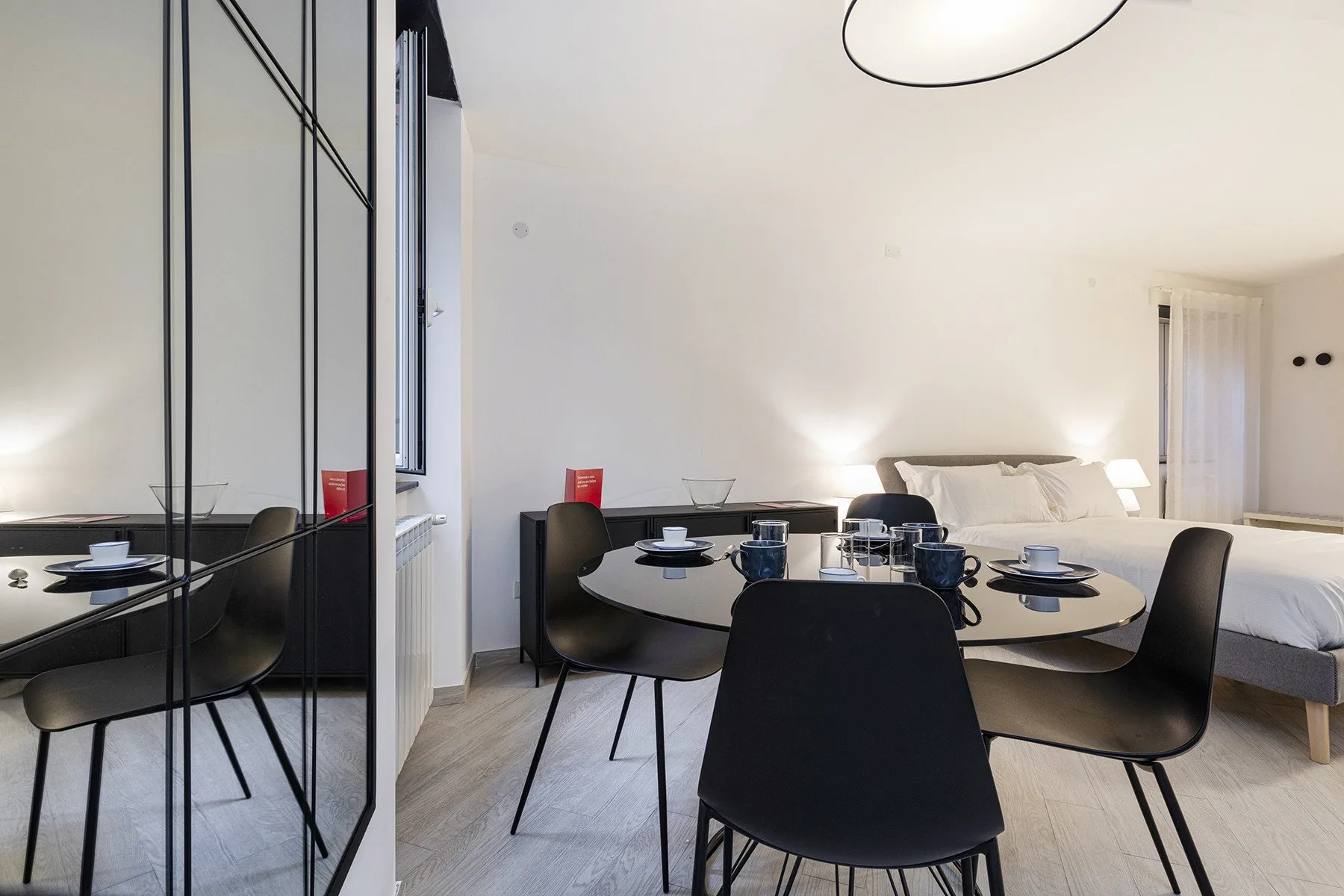 Un dormitorio con una mesa redonda y sillas junto a la cama.