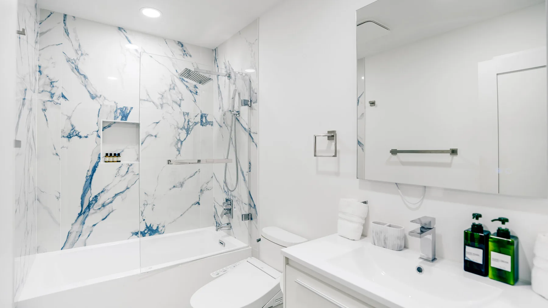 Un baño luminoso con bañera, ducha de pared y lavabo.