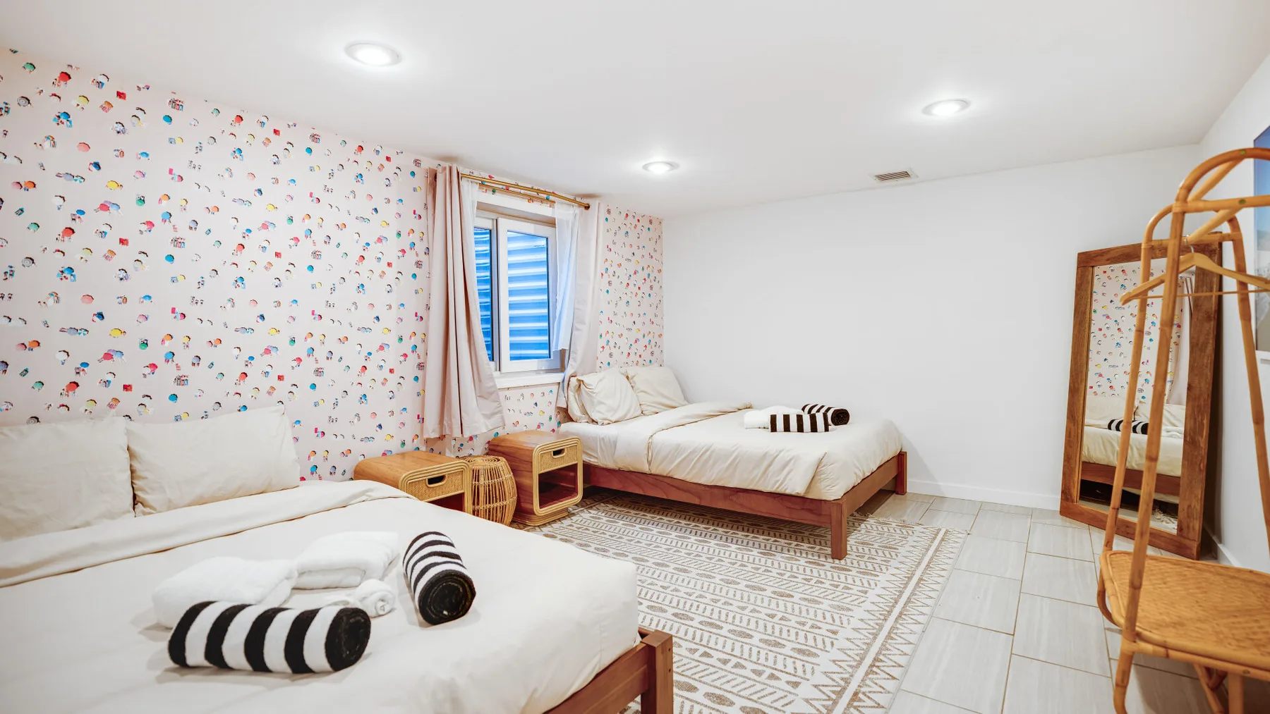 Un dormitorio con dos camas y papel tapiz estampado.