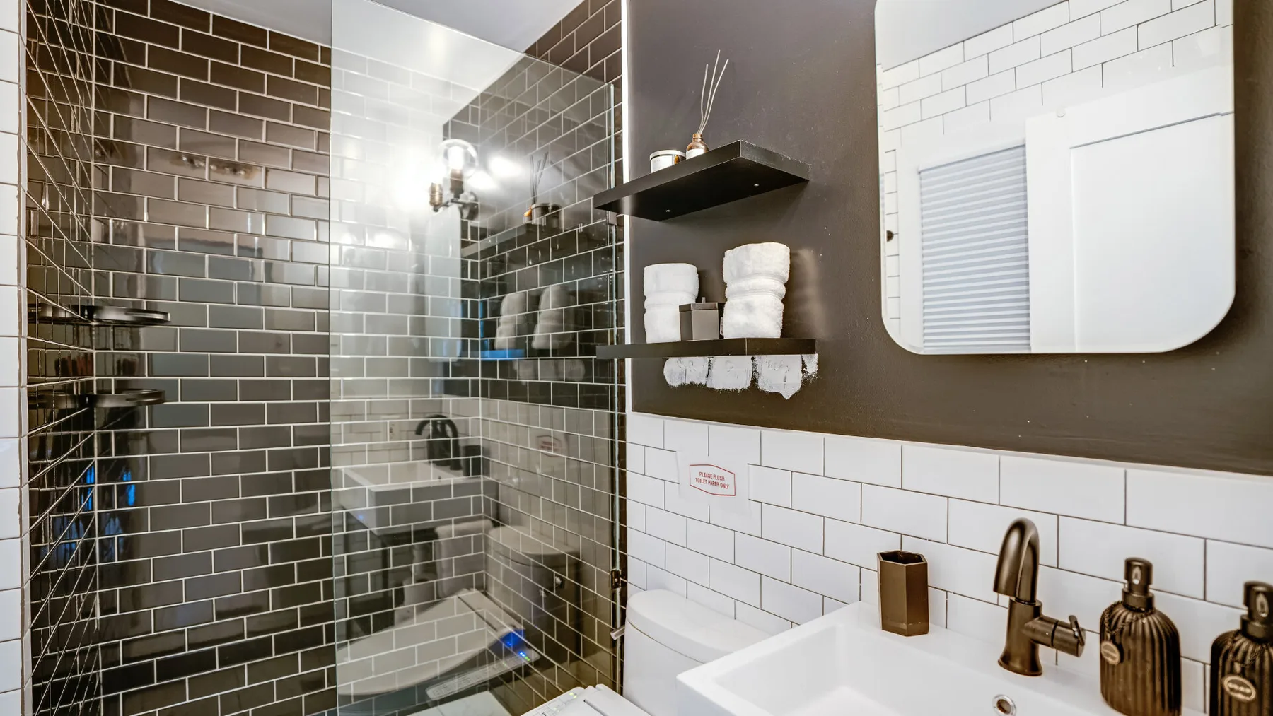 Un baño alicatado con ducha de vidrio y lavabo.
