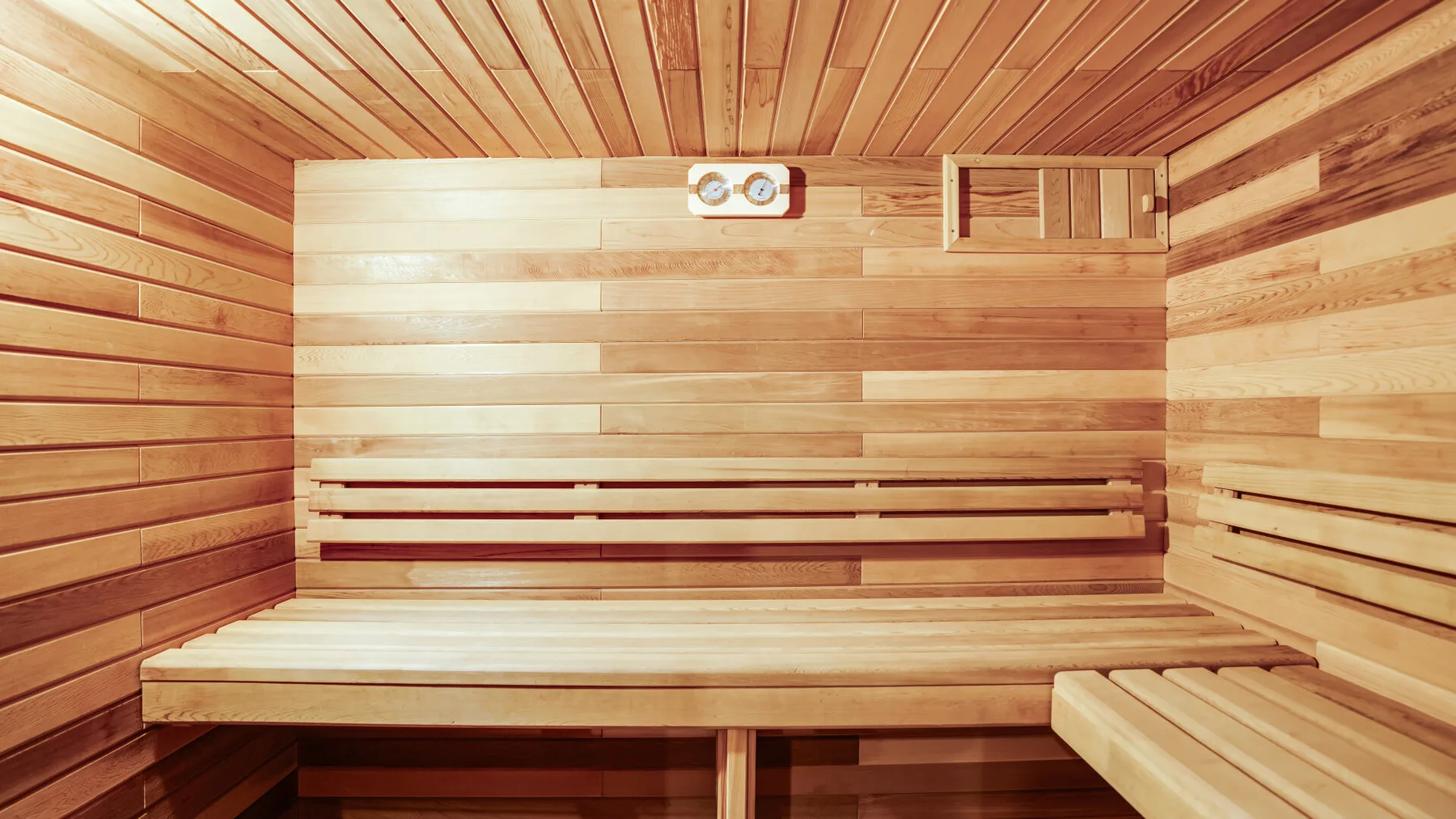 Una sauna revestida de madera con asientos escalonados.