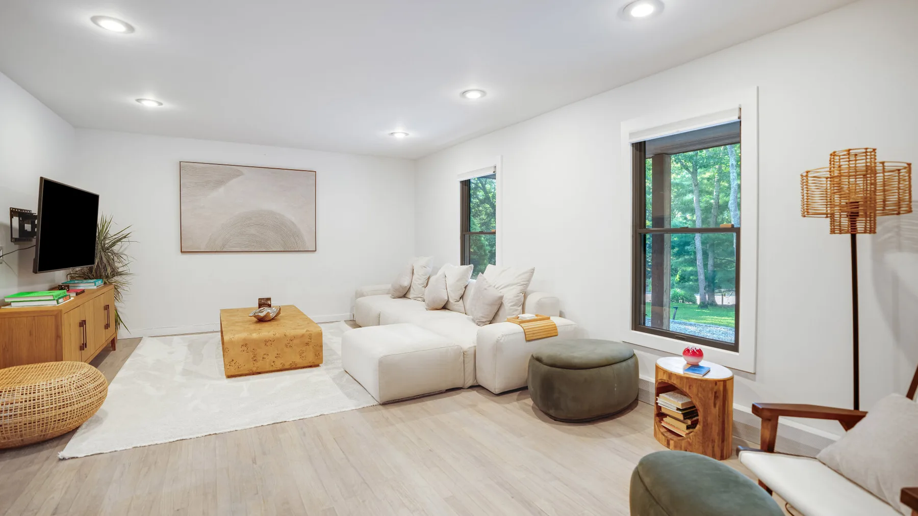 Una sala luminosa con asientos claros y grandes ventanas con vistas a la vegetación.
