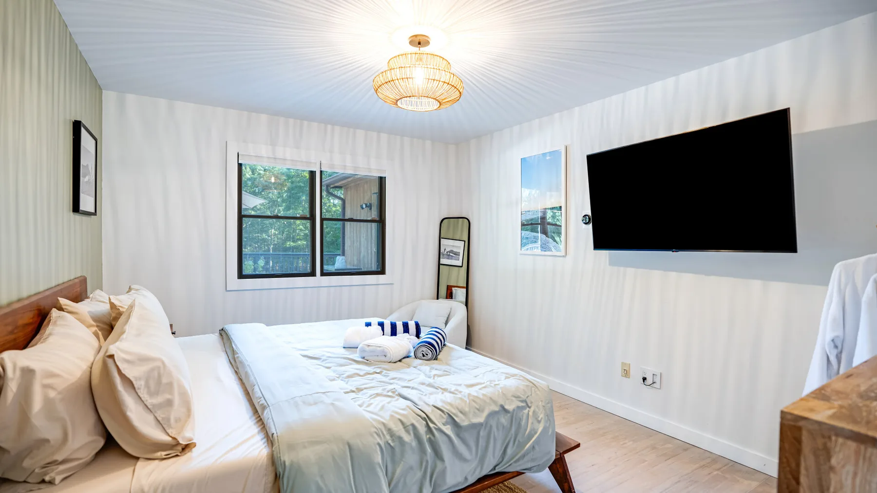 Un dormitorio con dos camas, un televisor en la pared y una ventana.