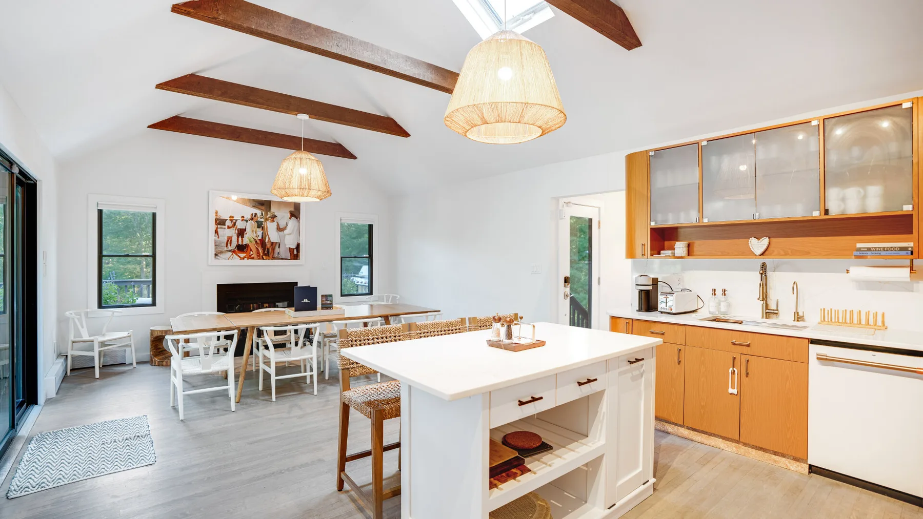 Una luminosa cocina con comedor cuenta con una gran isla central y vigas de madera en el techo.