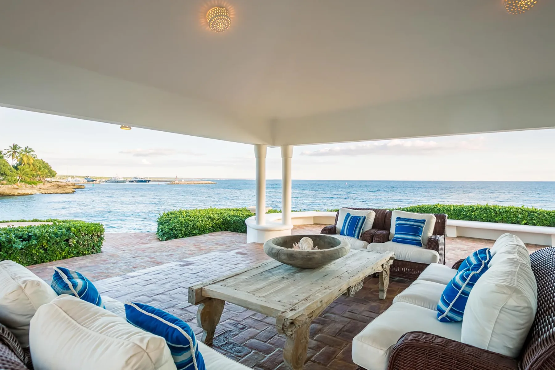 A covered patio seating area overlooks the ocean.