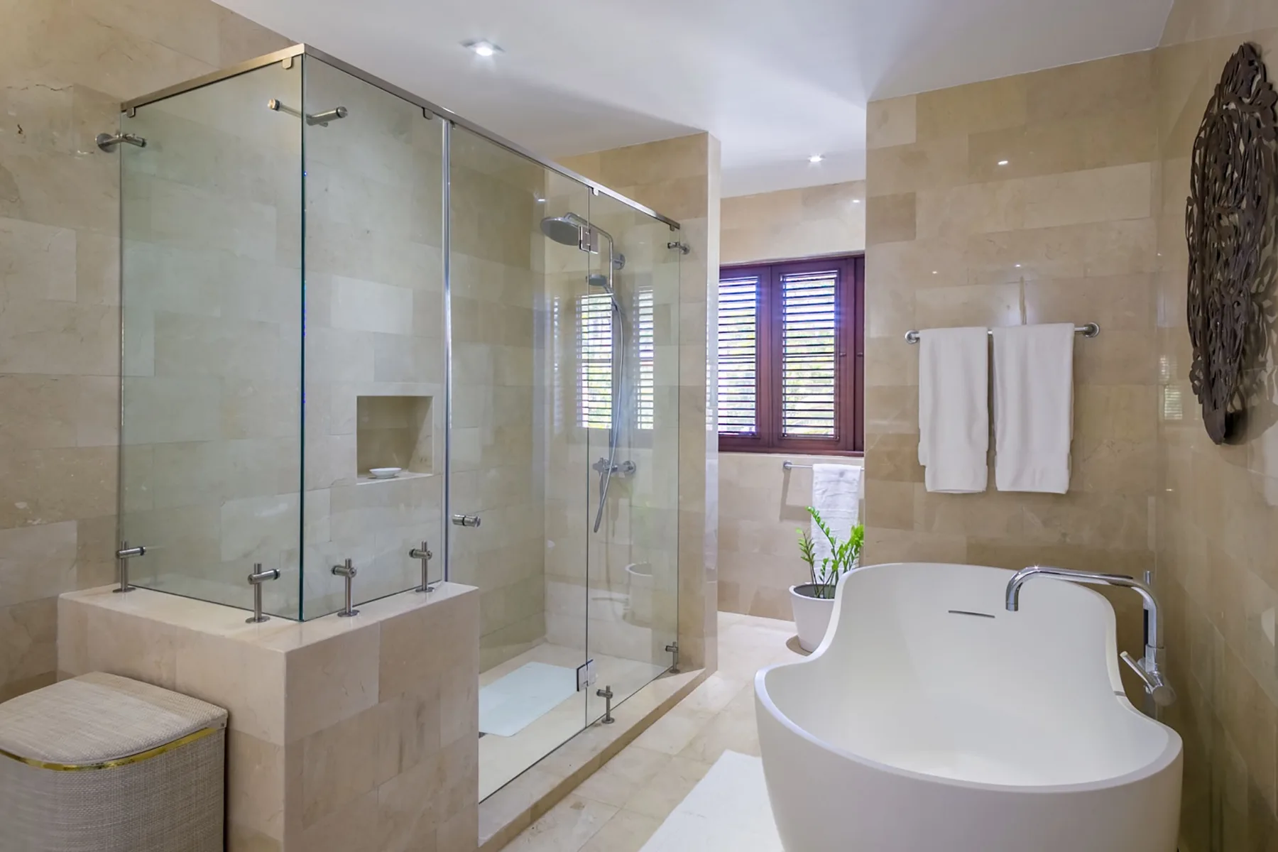 A spacious bathroom with a glass shower and a freestanding bathtub.