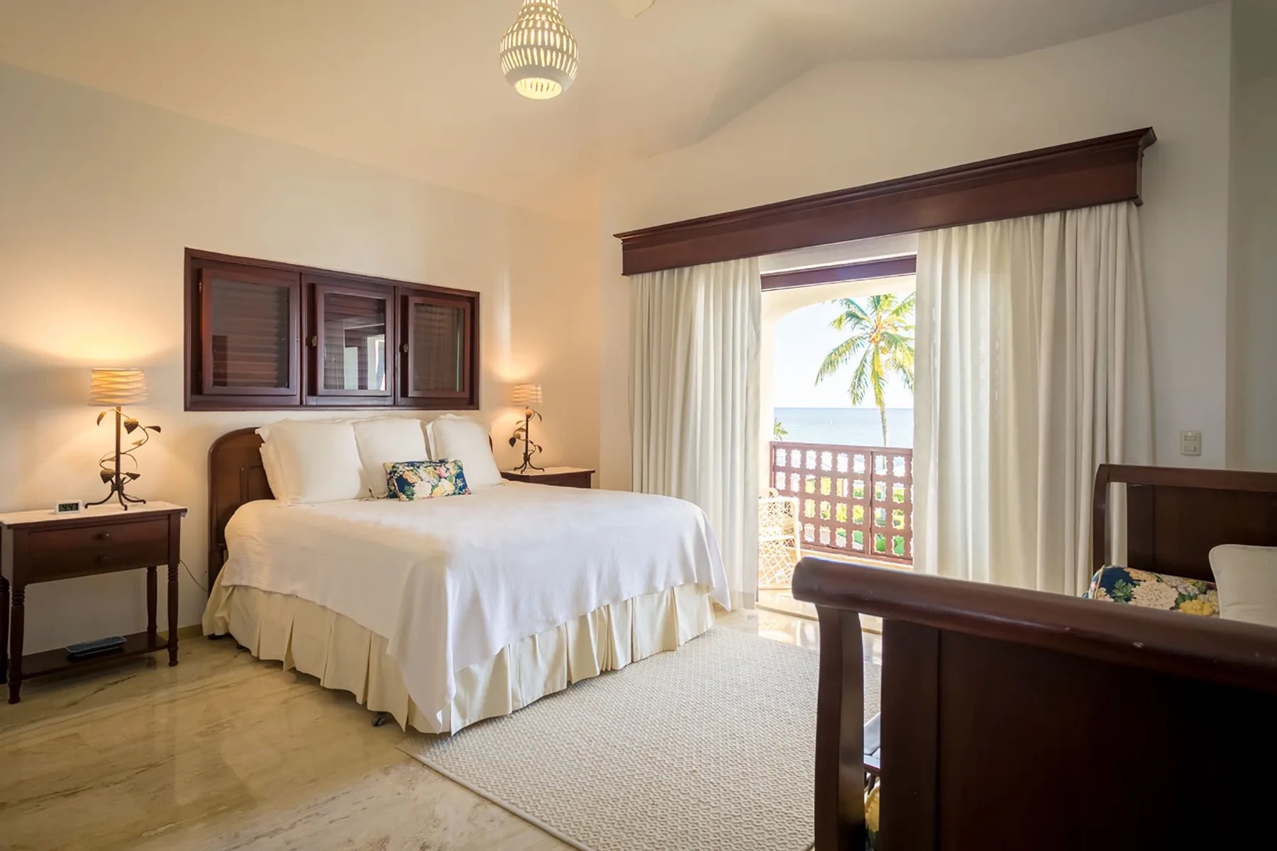 A bedroom with a bed, bedside tables, and a bright window.