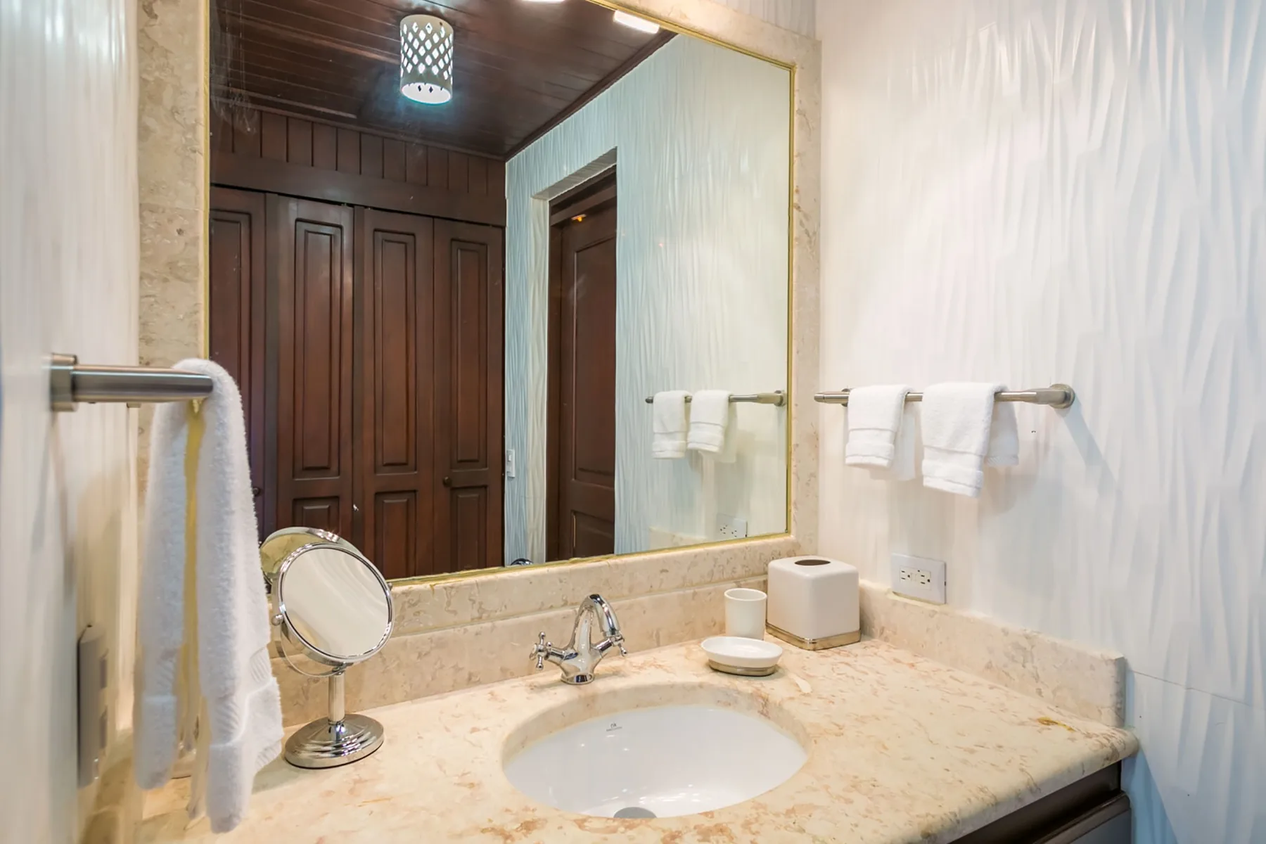 A bathroom vanity with a sink and a large mirror above the counter.