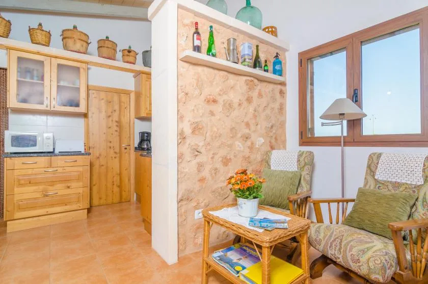 Una luminosa zona de estar con asientos de mimbre y una mesita junto a la cocina.