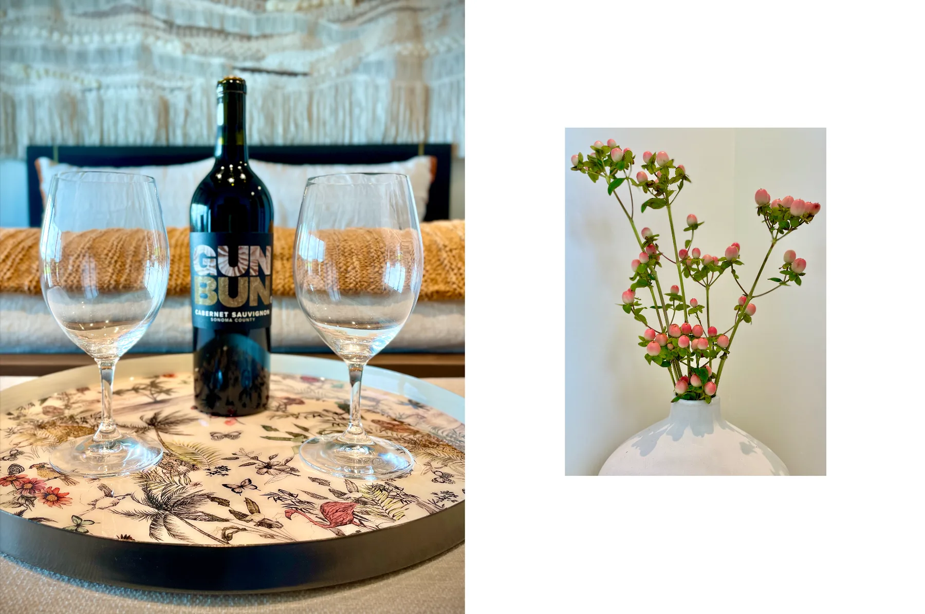 A wine bottle and glasses sit on a table beside a vase of flowers.