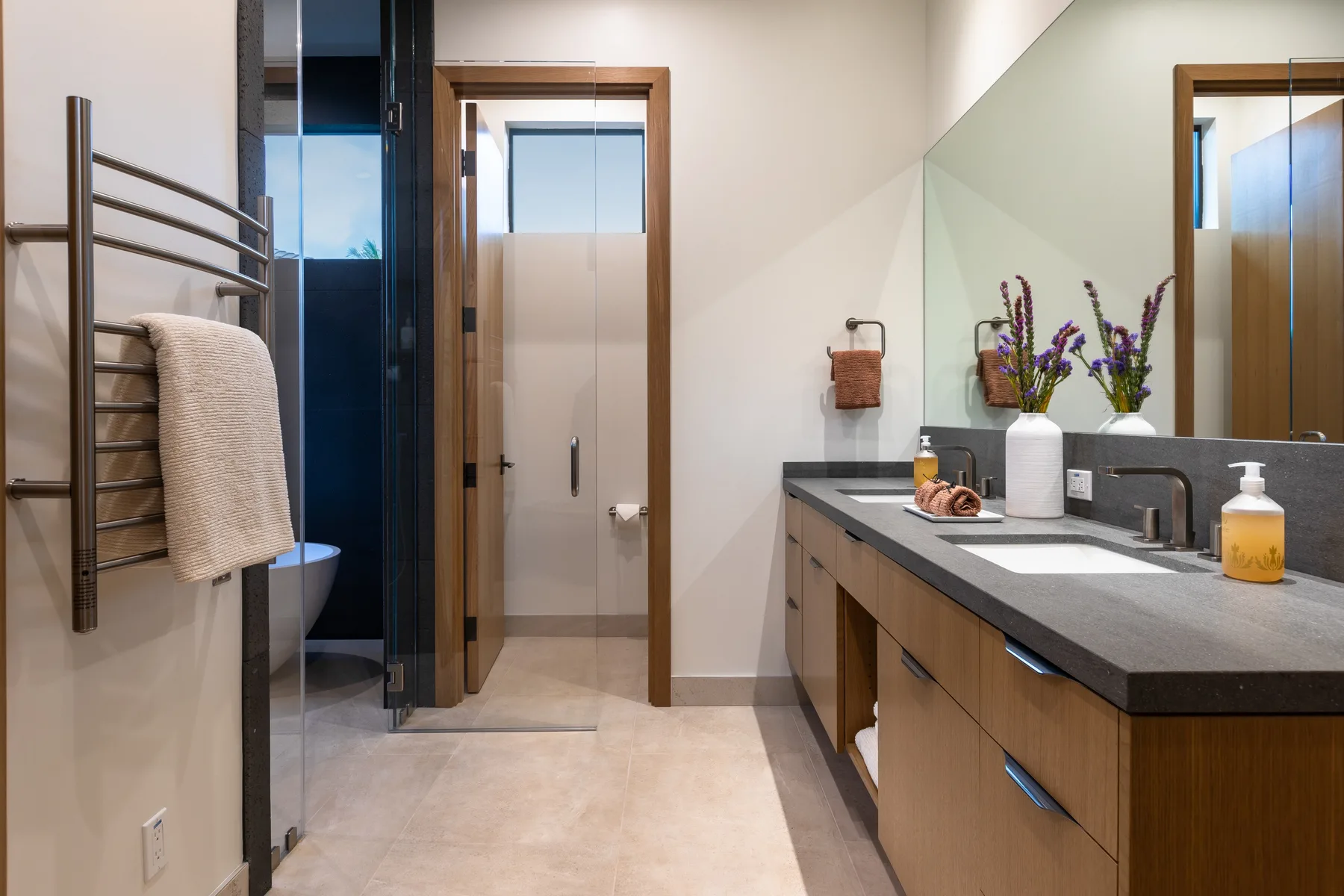 A bathroom vanity with a long countertop and a doorway beside it.