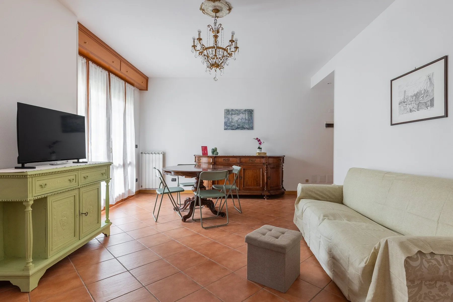 Una luminosa sala de estar y comedor tiene una mesa, asientos y un televisor.