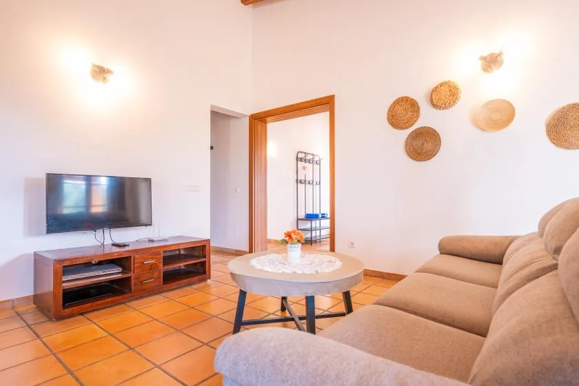 A living room with a television, seating, and a round coffee table.