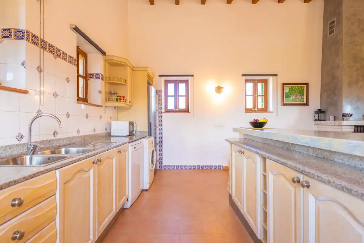 A bright kitchen with counters and wooden cabinets along both sides.