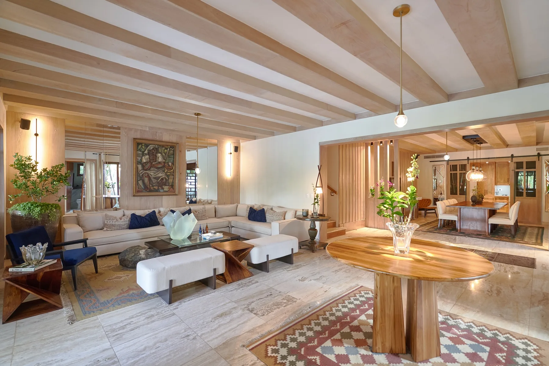 A spacious living room with seating and a round wooden table.