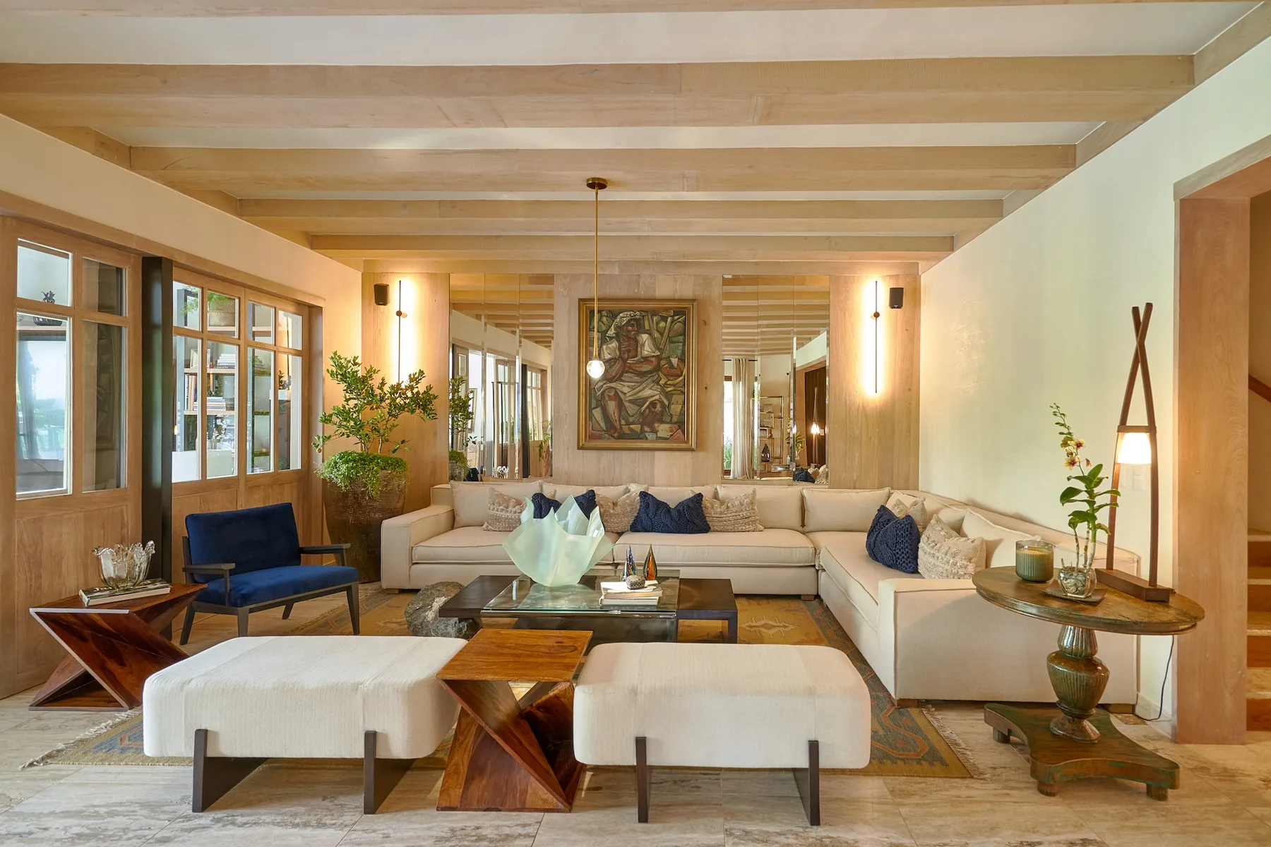 A bright living room with sectional seating, a coffee table, and large windows.