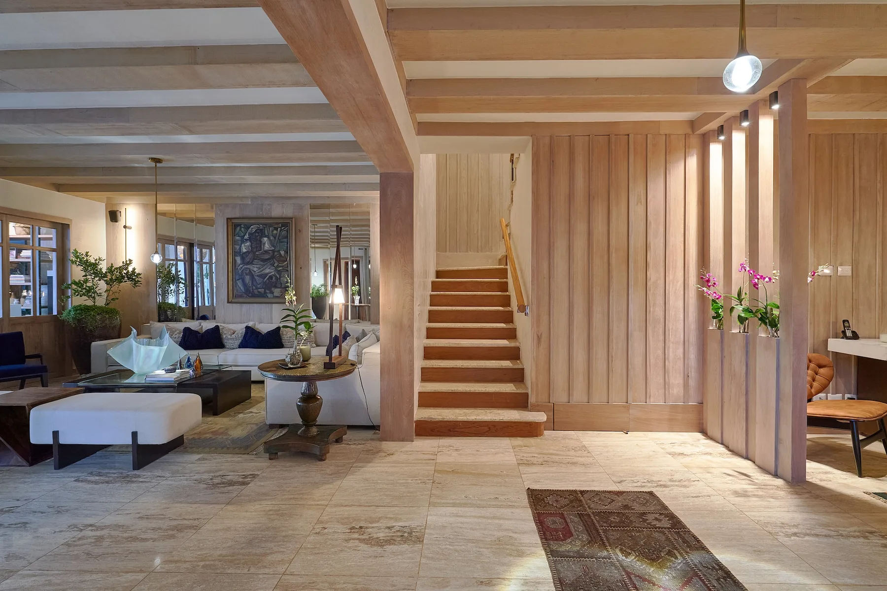 A wood-paneled interior with a staircase beside a living area.