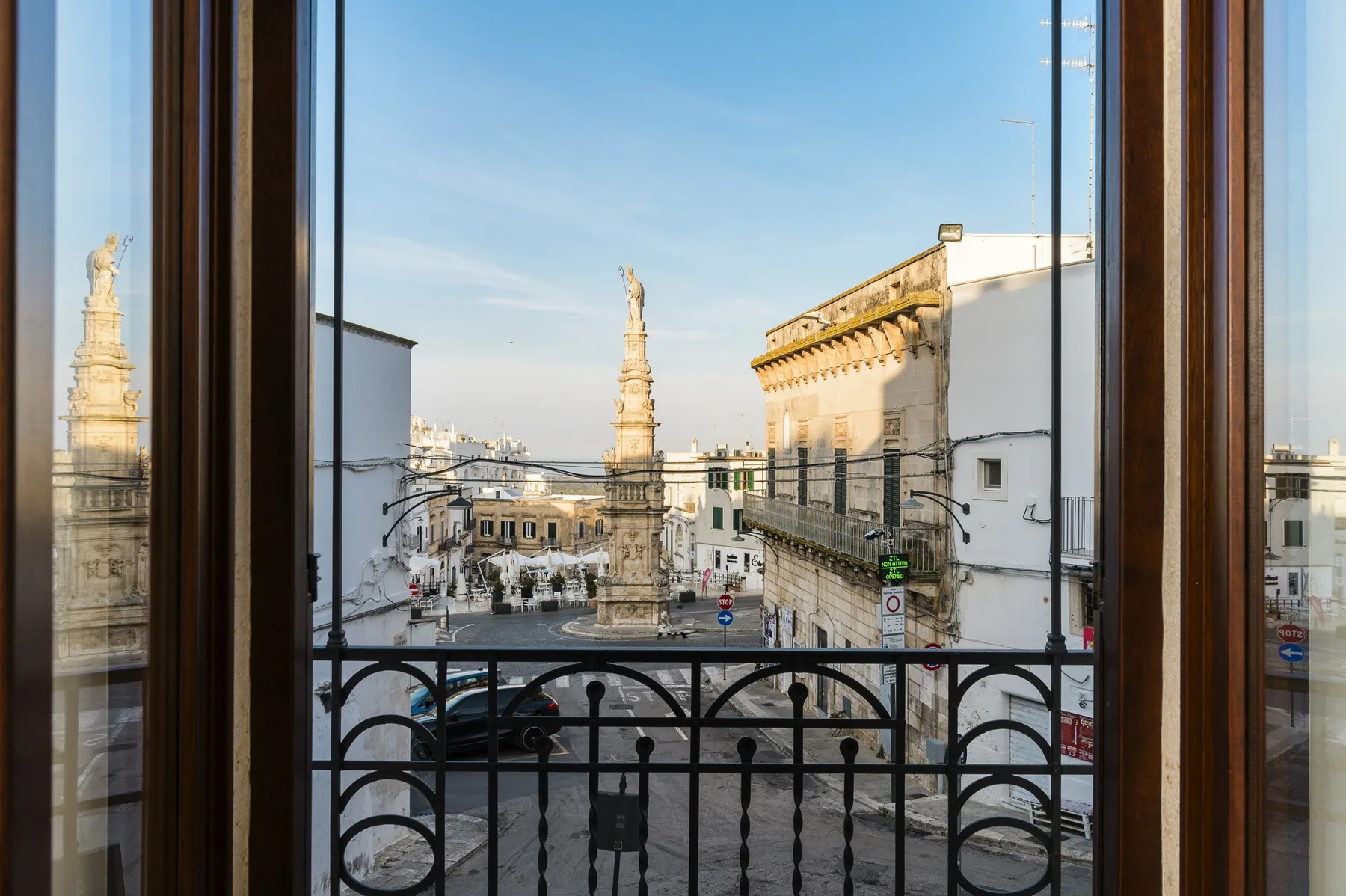 A city square with historic buildings and a view through an open window.