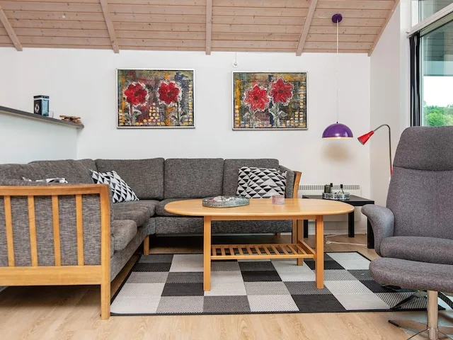 A living room with a sectional seating area, coffee table, and wall art.