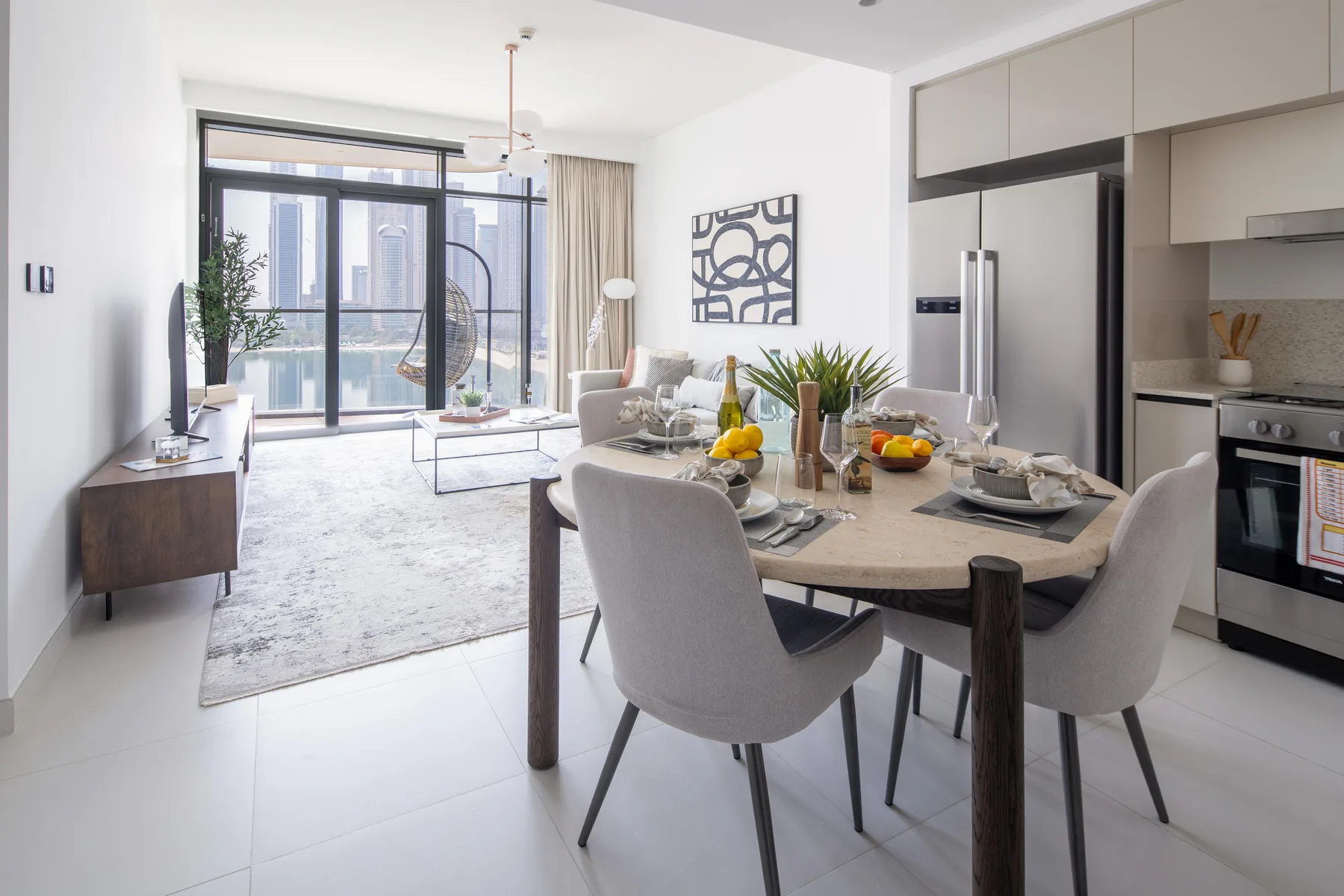 A bright open-plan dining and living area with large windows and a set dining table.