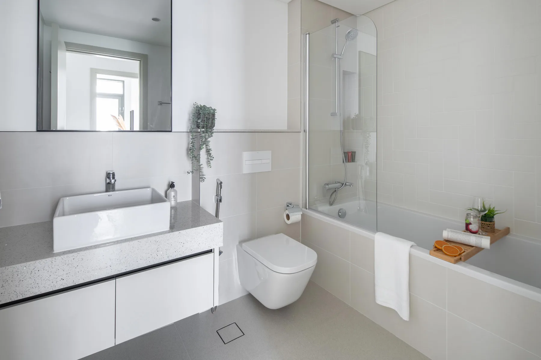 A bright bathroom with a sink, toilet, and bathtub with a shower.