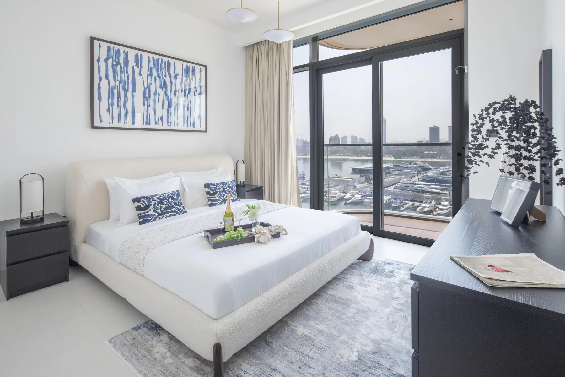 A bright bedroom features a neatly made bed beside a large window.