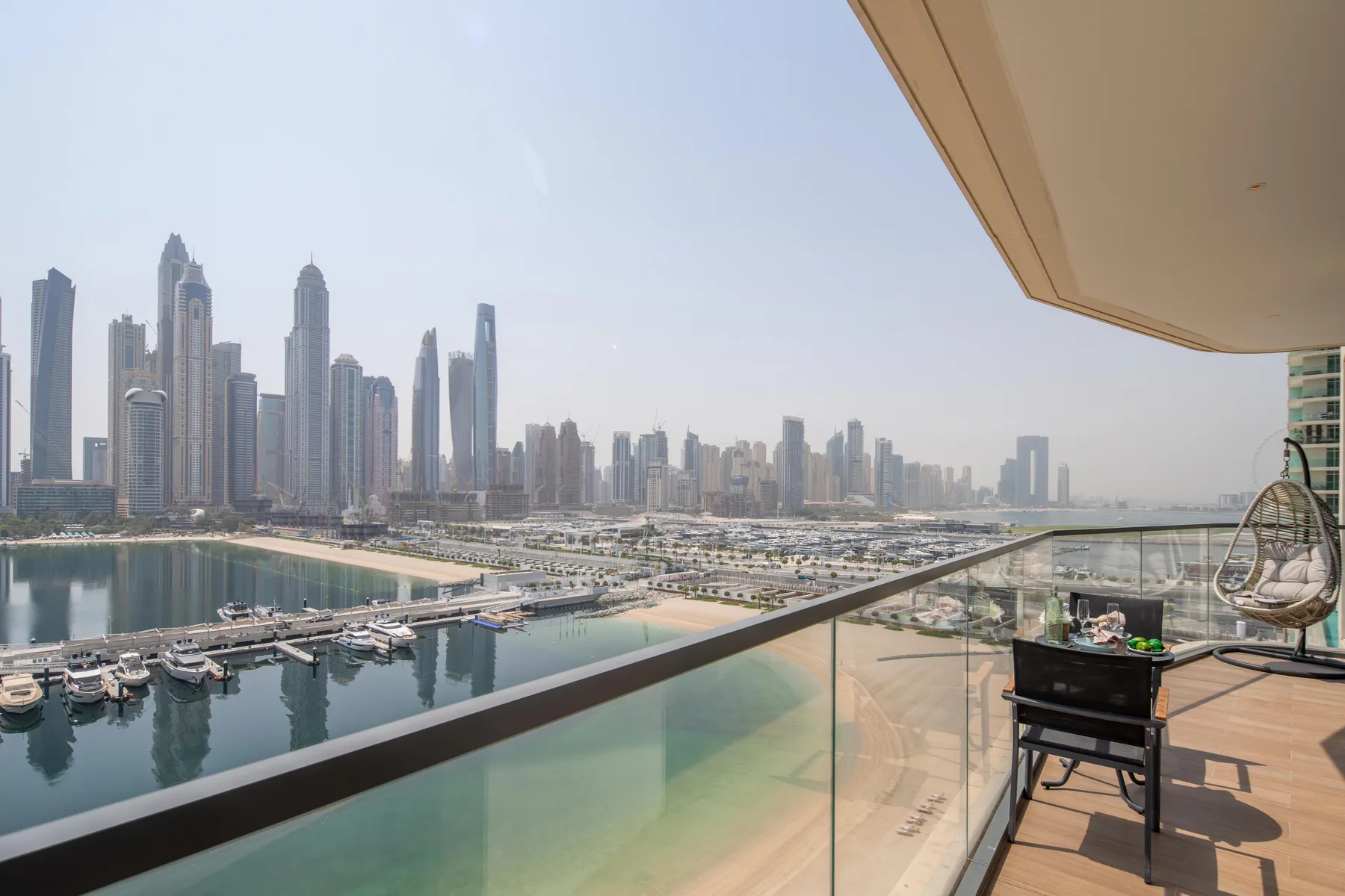 A balcony overlooks a waterfront marina and a skyline of tall buildings.