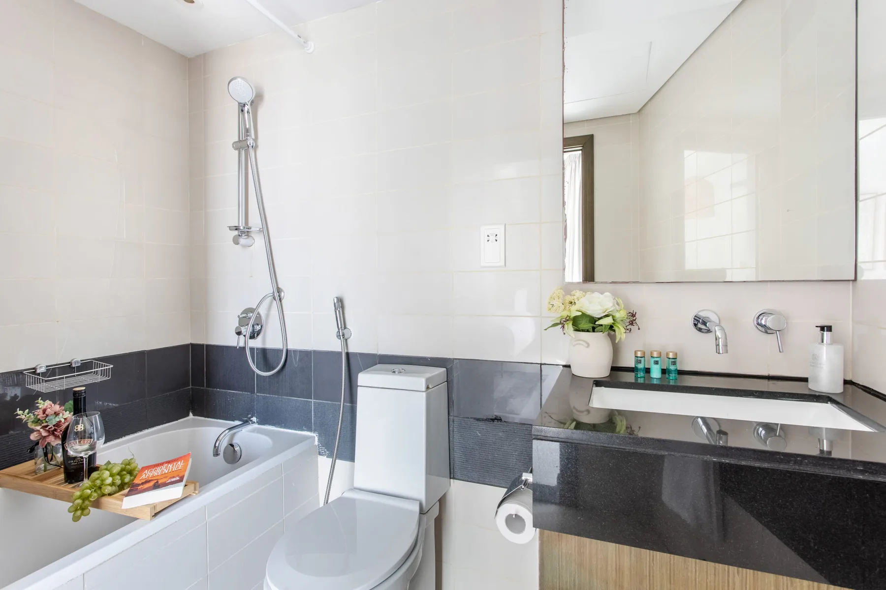A bright bathroom with a bathtub, toilet, and vanity.