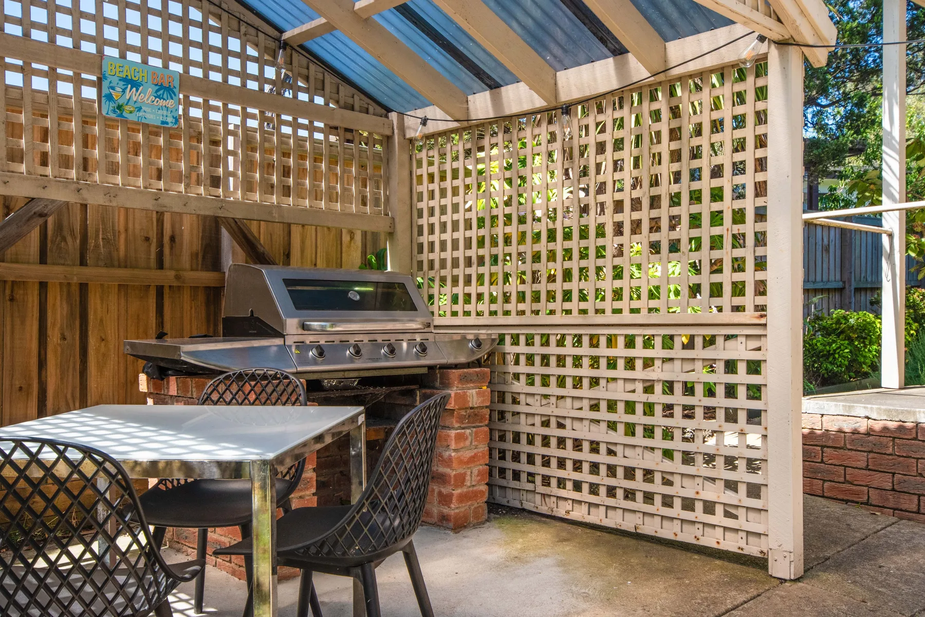 Un patio exterior cubierto con una parrilla y una mesa.