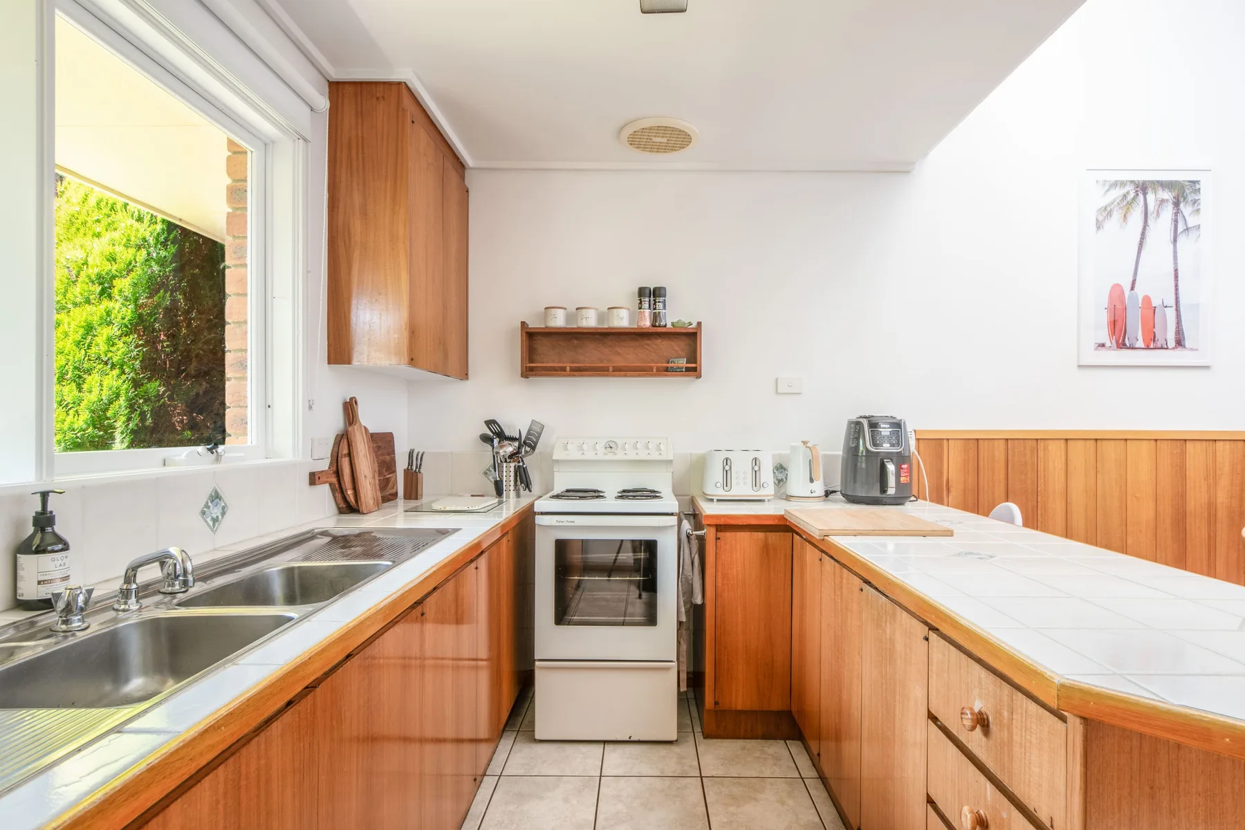 Una cocina luminosa con gabinetes de madera, encimeras y una estufa.
