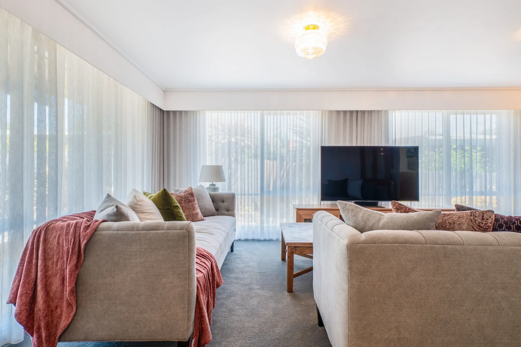 Una sala luminosa con asientos dispuestos alrededor de un televisor.