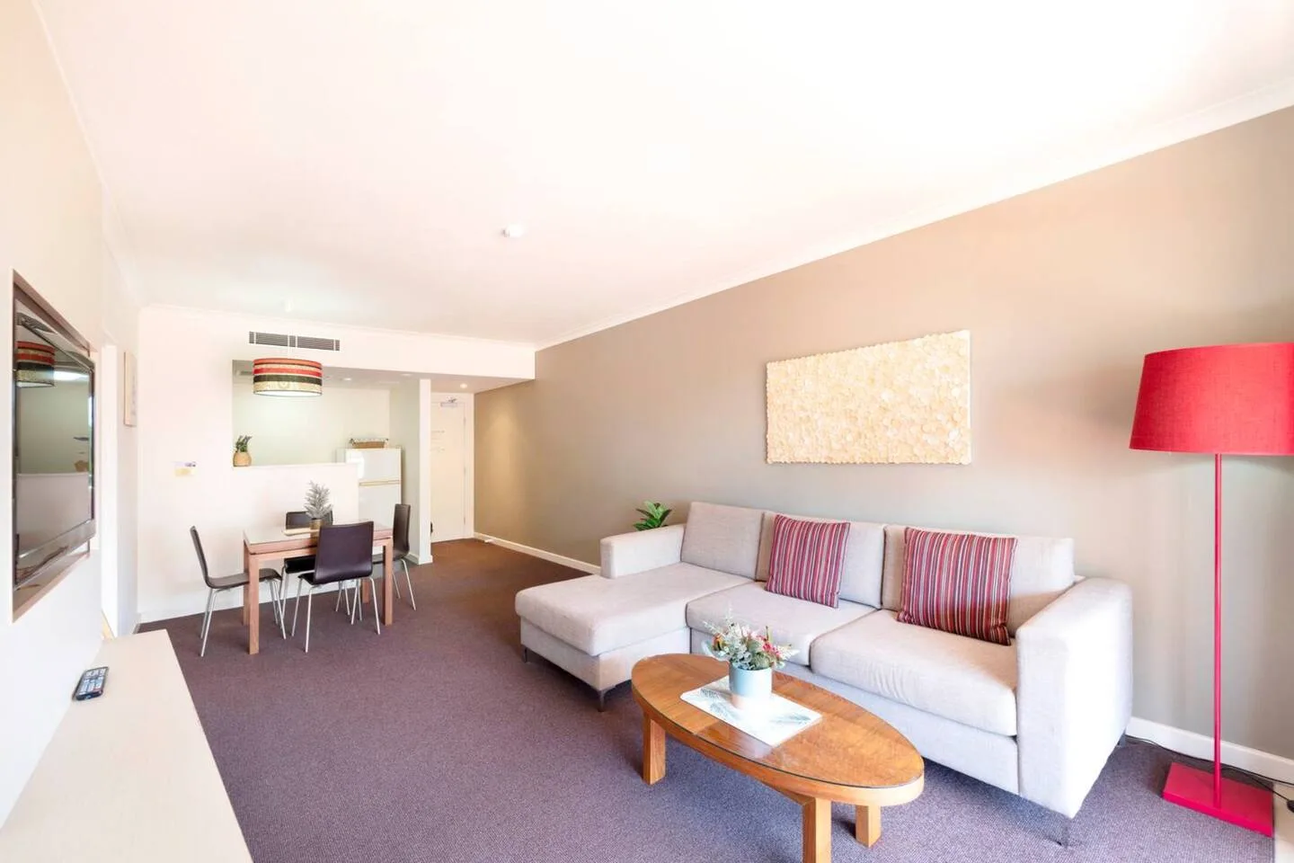 A living room with seating, a coffee table, and a dining area.