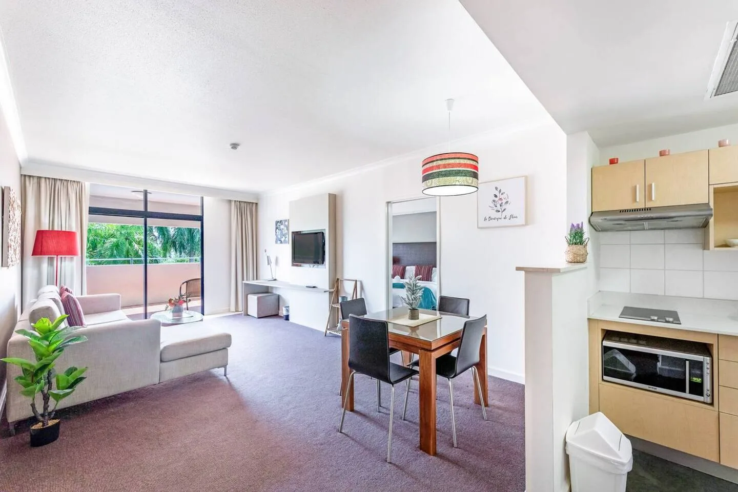 Large glass doors open out from the living area to the balcony.