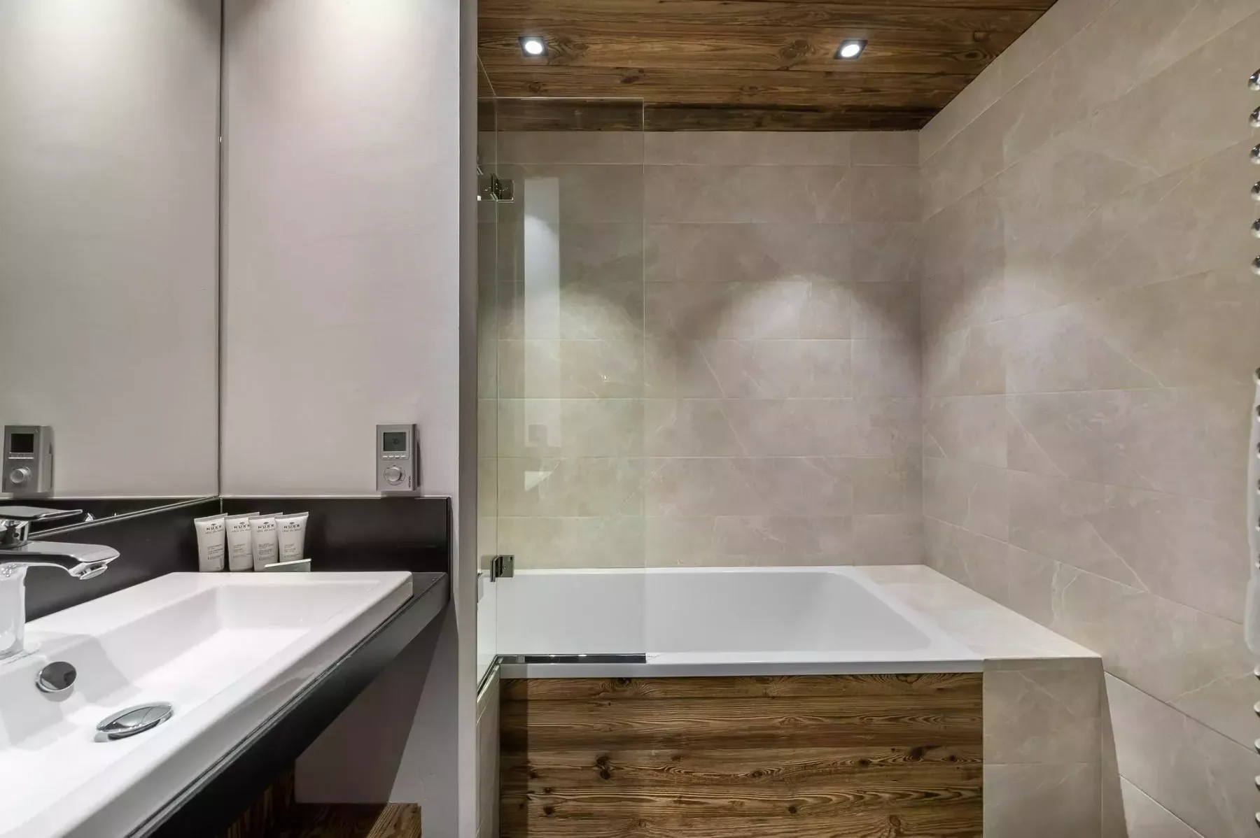 A bathroom with a built-in bathtub and a sink beside it.