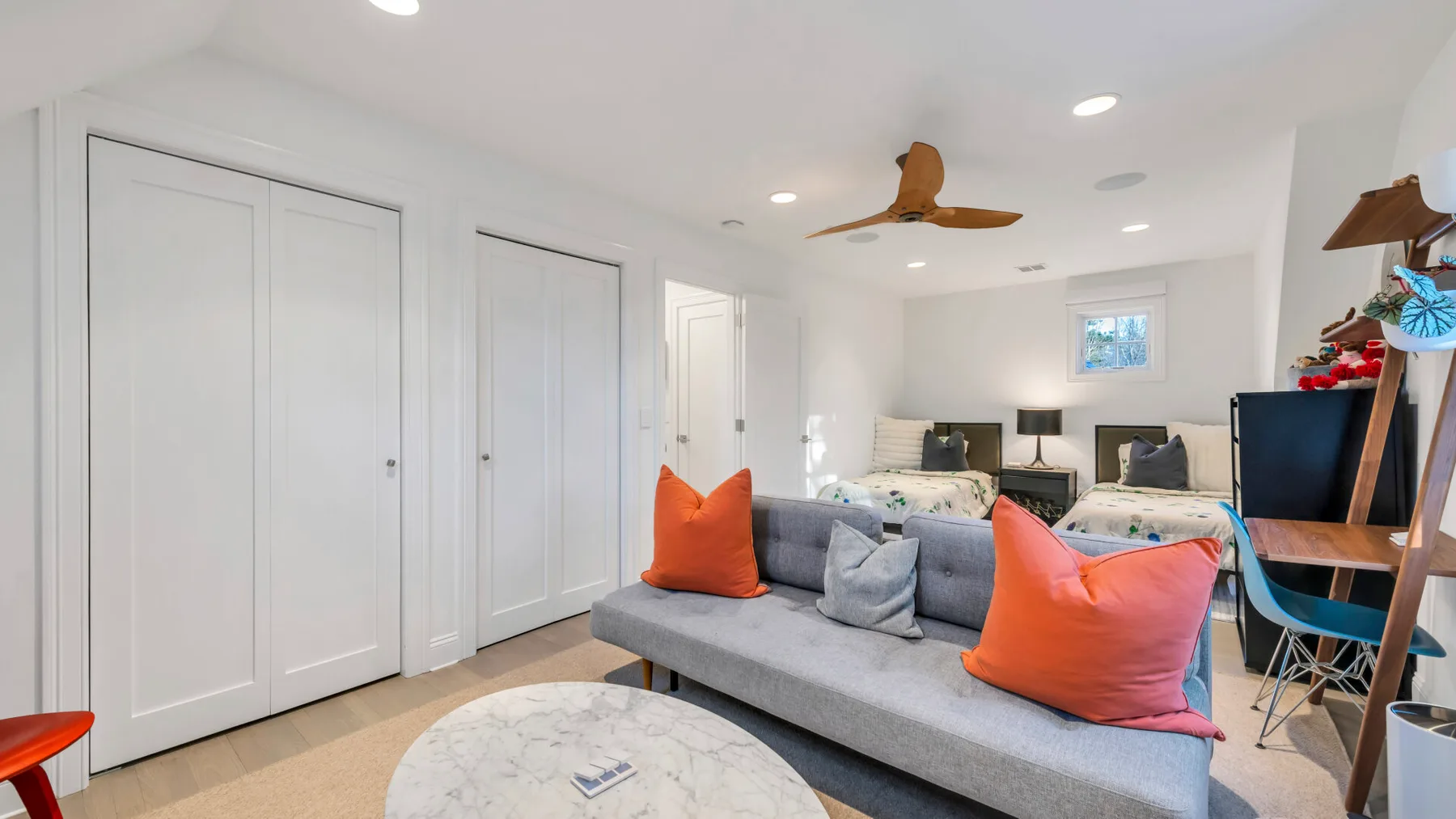 A bright living room with gray seating and colorful throw pillows.