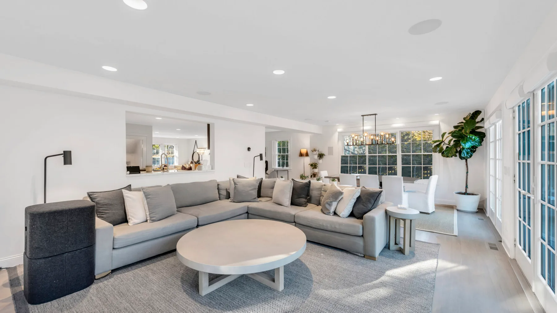 A bright living room with a large sectional sofa and round coffee table.