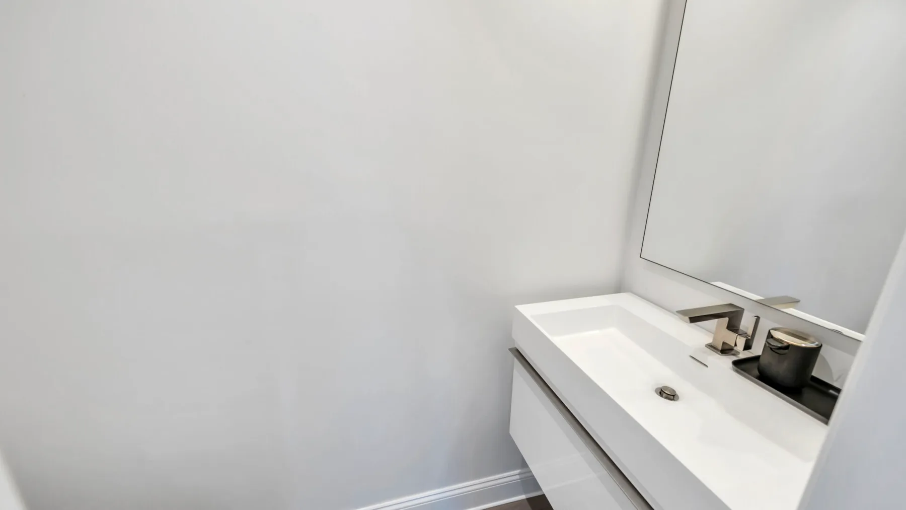 Bathroom vanity with a sink and a large wall mirror.