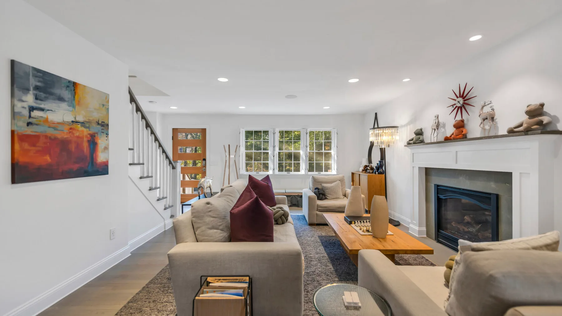 A bright living room with seating, a fireplace, and colorful wall art.