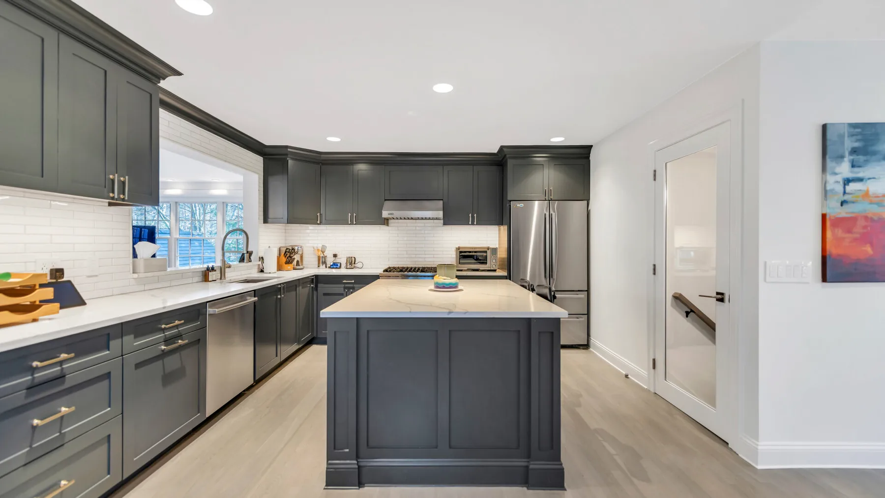 A modern kitchen with dark cabinets and a central island.