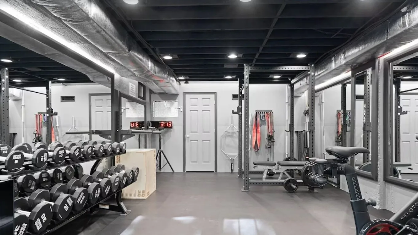 A gym with rows of weights and exercise equipment.
