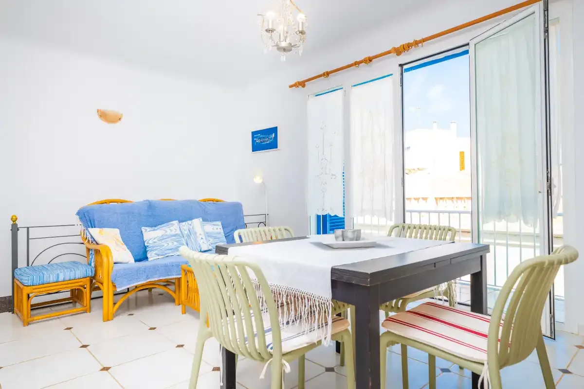 Un comedor luminoso con una mesa, sillas y asientos azules.