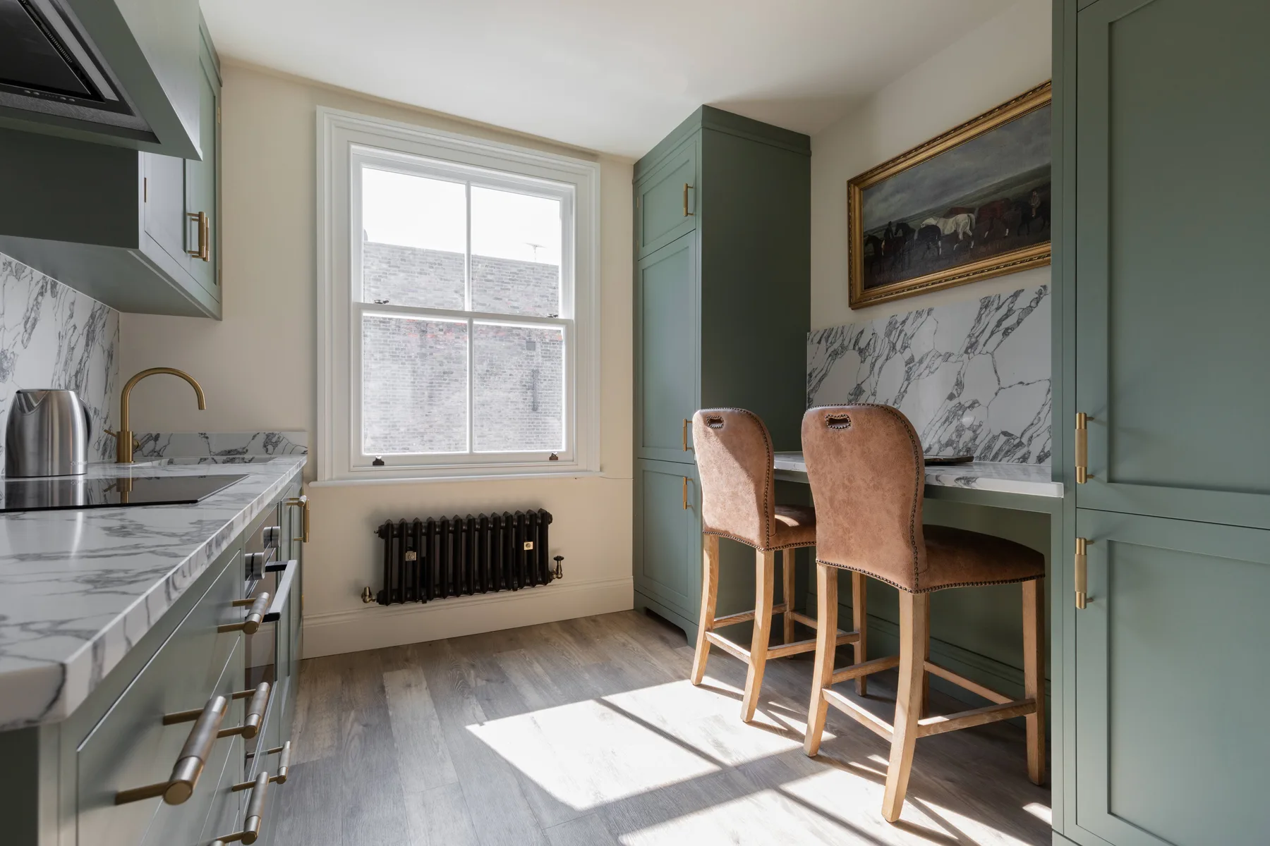A bright kitchen with a marble counter, window, and small dining area.